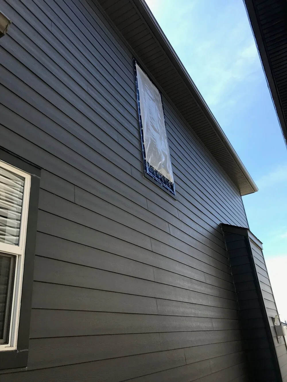Close-up of newly installed dark gray fiber cement siding on a residential home in Metamora, MI, completed by The Exterior Zone.